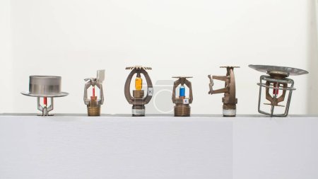 Fire sprinkler heads with fusible links and frangible bulbs