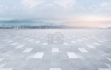 Empty brick square floor with panoramic city skyline and buildings