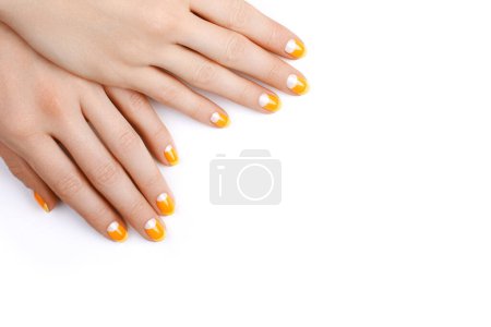 Foto de Beautiful Female Hands with bright Orange Manicure like Candy Corn on Yellow Background. Manicured Nails with Creative Gel Polish Design. Halloween Style - Imagen libre de derechos