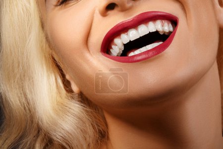Moitié portrait recadré de femme. Grosse beauté dentaire. Belle macro avec dents blanches parfaites. Maquillage rouge à lèvres sexy Fashion Lips. Blanchiment des dents et traitement de bien-être