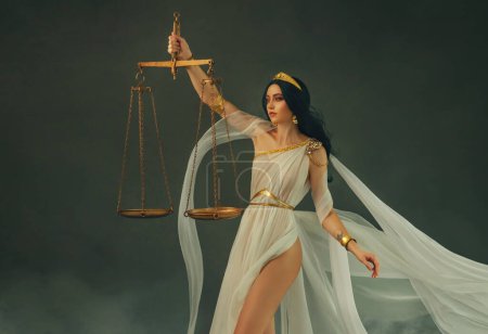 Photo for Portrait fantasy woman Greek goddess of justice Themis, holding golden scales in hands. White silk vintage dress old antique style flies waving in wind. Girl sexy Virgo astrology zodiac sign art photo - Royalty Free Image