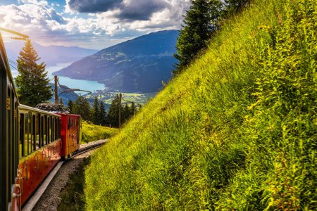 Roter Touristenzug, der von Wilderswil in der Nähe von Interlaken zu den berühmten Wildblumengärten der Schynige Platte in der Schweiz fährt. Retro-Zug fährt von Schynige Platte nach Interlaken. Schweiz.