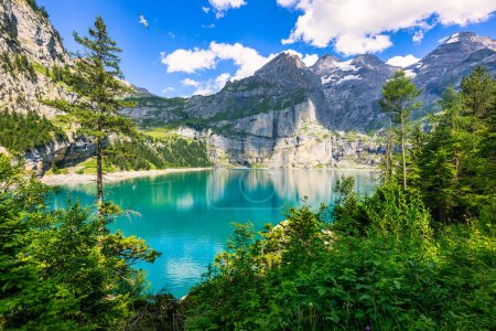 Berühmter Öschinensee mit Bluemlisalp an einem sonnigen Sommertag. Blick auf den azurblauen Öschinensee. Schweizer Alpen, Kandersteg. Tolle Tourquise Oeschinnensee mit Wasserfällen, Schweiz.