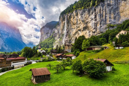Foto de Valle de Lauterbrunnen con famosa iglesia y cascada de Staubbach. Lauterbrunnen village, Berner Oberland, Suiza, Europa. Espectacular vista del valle de Lauterbrunnen en un día soleado, Suiza. - Imagen libre de derechos