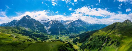 Foto de Vista de Grindelwald y verano Alpes suizos paisaje de montañas, campos verdes y picos altos en el fondo, Suiza, Bernese Oberland, Europa. - Imagen libre de derechos