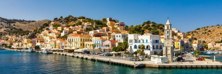 Foto de View of the beautiful greek island of Symi (Simi) with colourful houses and small boats. Greece, Symi island, view of the town of Symi (near Rhodes), Dodecanese. - Imagen libre de derechos