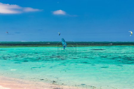 Kitesurfer in den Gewässern des Indischen Ozeans auf Mauritius. Kitesurfen im klaren Wasser des Indischen Ozeans am Strand von Le Morne auf Mauritius. Bestes Kitesurferlebnis auf Mauritius.