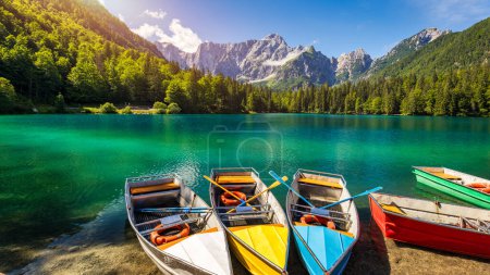 Lac pittoresque Lago Fusine avec des bateaux colorés. Lac Fusine avec pic Mangart sur fond. Destinations de voyages populaires, Julian Alps. Localisation : Tarvisio comune, Province d'Udine, Italie, Europe.