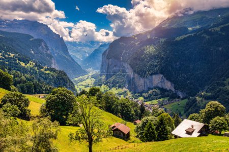 Amazing summer landscape of touristic alpine village Lauterbrunnen with famous church and Staubbach waterfall. Location: Lauterbrunnen village, Berner Oberland, Switzerland, Europe.