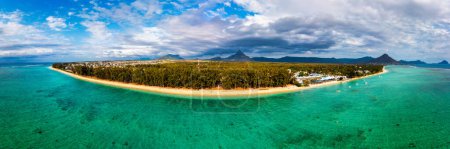 Aerial Landscape view of Flic en Flac beach with cityscape of Flic en Flac town and Mauritius mountain landscape in the background. Best tropical beaches in Flic en Flac, Mauritius island.