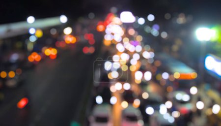 Photo for Defocused vehicles on traffic signal photo. Vehicle and other lights creating bokeh effect. Night, top down view. - Royalty Free Image