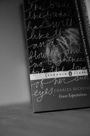 Photo for A vertical grayscale closeup of Charles Dickens's Great Expectations novel on a shelf. - Royalty Free Image