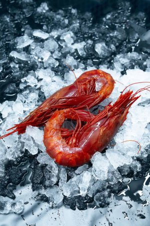 Téléchargez les photos : Un plan vertical de crevettes rouges fraîches crues sur de la glace affichée sur un marché - en image libre de droit