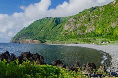 Foto de Un hermoso paisaje de cascada Poco do Bacalhau y río con montaña rocosa en la isla de Flores, Azores, Portugal - Imagen libre de derechos