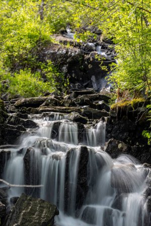 Foto de Un disparo vertical de una hermosa cascada salpicando la cascada en las montañas de Noruega - Imagen libre de derechos