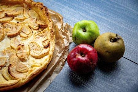 Photo for A closeup shot of an apple pie with colorful apples near - Royalty Free Image