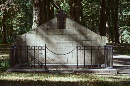 Téléchargez les photos : Une vieille tombe avec une grande pierre tombale et une clôture métallique à chaîne dans le grand cimetière de Riga, Lettonie - en image libre de droit