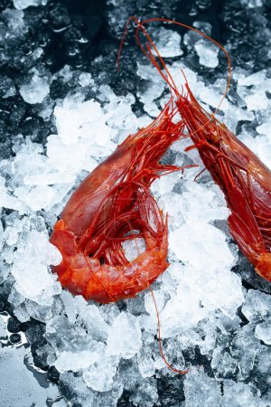 Téléchargez les photos : Un plan vertical de crevettes rouges fraîches crues sur de la glace affichée sur un marché - en image libre de droit
