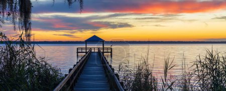 Téléchargez les photos : Un quai en bois avec des balustrades au lac Crescent au coucher du soleil - en image libre de droit
