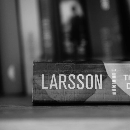 Photo for A vertical grayscale closeup of Stieg Larsson's The Girl With The Dragon Tattoo novel on a shelf. - Royalty Free Image
