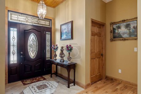Téléchargez les photos : Une belle maison rustique intérieure avec une grande porte noire, éclairage, et des décorations - en image libre de droit