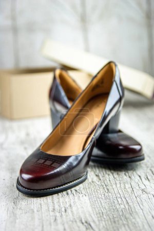 Photo for A vertical shot of brown women's heels on a wooden surface - Royalty Free Image
