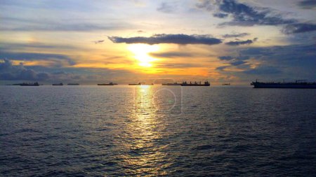 Foto de La vista del mar con siluetas de barcos al atardecer. - Imagen libre de derechos