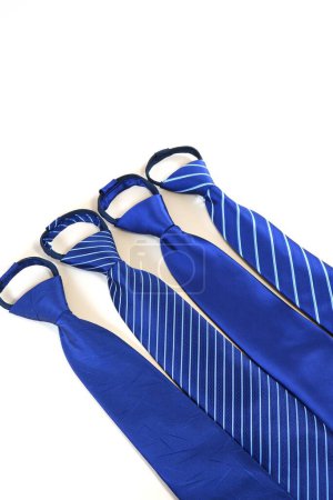 Foto de Una toma vertical de un grupo de corbatas de poliéster azul aisladas sobre un fondo blanco. - Imagen libre de derechos