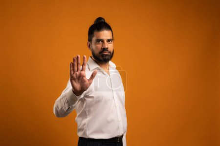 Téléchargez les photos : Un beau cliché d'un homme hispanique montrant des émotions devant un fond orange - en image libre de droit