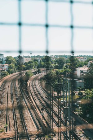 Téléchargez les photos : Un plan en angle élevé de voies ferrées vues à travers une clôture - en image libre de droit