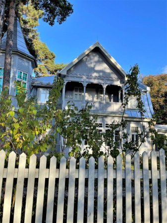 Foto de Un exterior de una antigua casa con una valla de madera en primer plano - Imagen libre de derechos