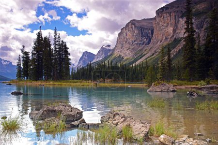 Foto de Una vista horizontal de Spirit Island con grandes montañas y árboles reflejándose en el agua Alberta, Canadá - Imagen libre de derechos