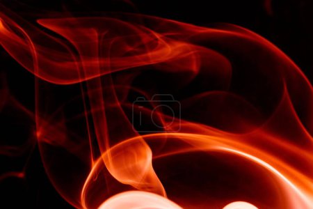 Foto de Un fondo de pantalla dramático de humo rojo que se asemeja a llamas de fuego en el fondo negro - Imagen libre de derechos