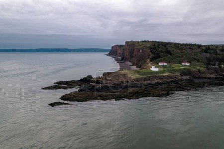 Photo for An aerial view of scenic cliffs with calm sea water against a cloudy sky - Royalty Free Image