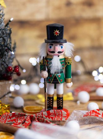 Téléchargez les photos : Un plan vertical d'un jouet de casse-noix en bois sur la table avec des décorations de Noël - en image libre de droit