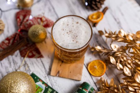 Téléchargez les photos : Une vue de dessus d'un verre de bière de Noël servi avec de belles décorations lumineuses - en image libre de droit