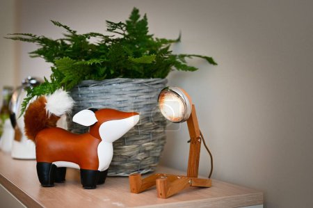 Téléchargez les photos : Gros plan d'un jouet de renard, décor de lampe et plante sur une cabane en bois - en image libre de droit