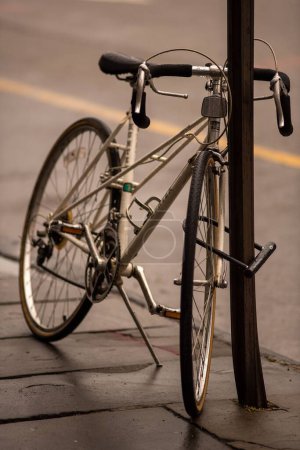 Photo for A vertical shot of a parked bicycle at the side of a road - Royalty Free Image