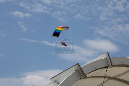 Téléchargez les photos : Angle bas d'une personne volant en parachute avec un ciel nuageux et ensoleillé - en image libre de droit