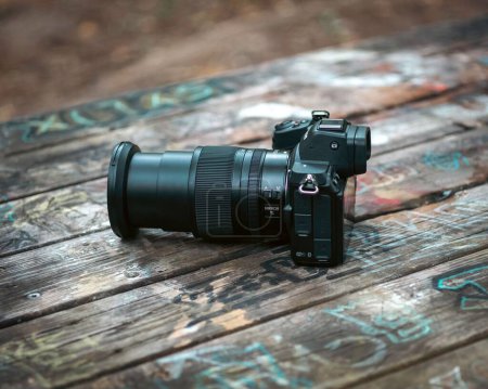 Foto de Una cámara Nikon Z5 ingenio ha 24-70 lente kit jugado en un banco decorado en un parque local. - Imagen libre de derechos