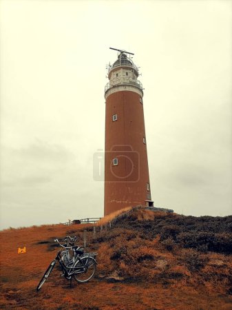 Photo for A vertical shot of the Texel lighthouse and bikes, Texel island, the Netherlands - Royalty Free Image