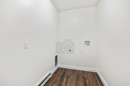 Photo for The interior of a room with a parquet floor, power outlets on the white walls and a baseboard heater - Royalty Free Image