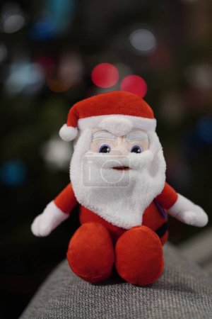 Téléchargez les photos : Une peluche du Père Noël de marque Milka assise sur un canapé en matériau - en image libre de droit