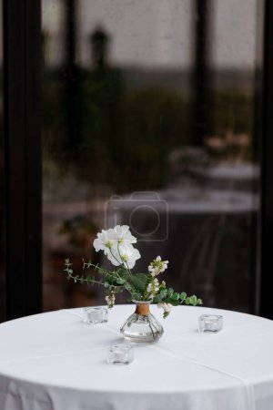 Foto de Un hermoso ramo de flores en una mesa de comedor con espejo borroso en el fondo, plano vertical - Imagen libre de derechos