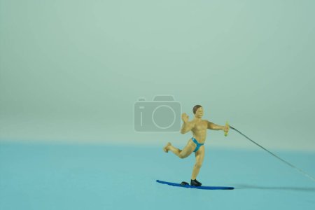 Téléchargez les photos : Un homme ski nautique, eau de mer bleue, vacances sur la côte de la mer - en image libre de droit