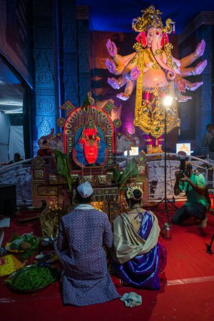 Téléchargez les photos : Un couple priant devant l'idole du Seigneur Ganesha, au festival hindou Ganesh Chaturthi à Mumbai, Inde - en image libre de droit