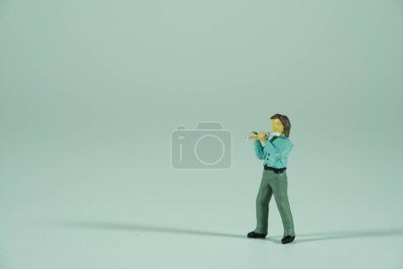 Téléchargez les photos : Musique de rue, homme jouant de la flûte, isolé sur fond clair, figurines miniatures scène - en image libre de droit