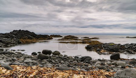 Téléchargez les photos : Une côte rocheuse dans la péninsule de Reykjanes sous un ciel nuageux pendant la journée - en image libre de droit