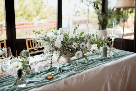 Foto de Una mesa bellamente decorada con flores blancas para la fiesta de bodas con sillas en fondo borroso - Imagen libre de derechos