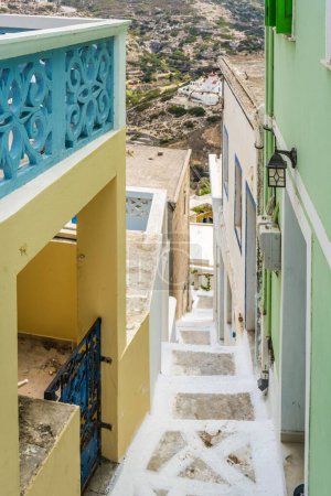 Una escalera de piedra estrecha en una calle con casas en Olympos Village en Karpathos, Grecia, plano vertical